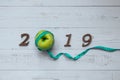 2019 Happy New Year for healthcare, Wellness and medical concept. green apple, measuring tape and wooden number Royalty Free Stock Photo