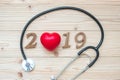 2019 Happy New Year for healthcare, Wellness and medical concept. Stethoscope with red heart and wooden number on table