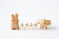 Happy New Year 2020, letter on wooden cube with lovely rabbit and elephant clay friend