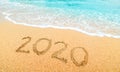 Happy New Year 2020, lettering on the beach with wave and  blue sea. Numbers 2020 year on the sea shore, New Years concept Royalty Free Stock Photo