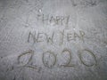 Happy new year 2020, lettering on the beach with wave and clear blue sea. Numbers 2020 year on the sea shore. Royalty Free Stock Photo