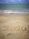 Happy new year 2020,lettering on the beach with wave and clear blue sea. Numbers 2020 year on the sea shore. Beautiful beach. Royalty Free Stock Photo