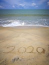 Happy new year 2020,lettering on the beach with wave and clear blue sea. Numbers 2020 year on the sea shore. Beautiful beach. Royalty Free Stock Photo