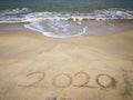 Happy new year 2020,lettering on the beach with wave and clear blue sea. Numbers 2020 year on the sea shore. Beautiful beach. Royalty Free Stock Photo