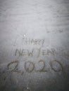 Happy new year 2020, lettering on the beach with wave and clear blue sea. Numbers 2020 year on the sea shore. Royalty Free Stock Photo