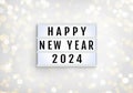 Happy New Year lightbox on lights blur bokeh white background. Light box with inscription Happy New Year and 2024. Decorative Royalty Free Stock Photo