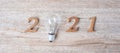 2021 Happy New year with lightbulb and wooden number on table. New Start, Idea, Creative, Innovation, Resolution, Solution,