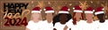 Happy New Year 2024 long horizontal banner. A group of diverse people wearing Santa hats.