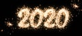 Happy New Year and Merry Christmas 2020 banner. Number 2020 written sparkling sparklers isolated on black background. Overlay