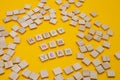 Happy New Year and Merry Christmas. Scrabble letters on yellow background. Letter tiles spelling celebration holiday