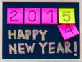 Happy New Year 2015 message hand written on blackboard, numbers stated on post-it notes, 2015 replacing 2014