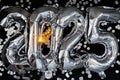 Happy new year 2025 metallic balloons with confetti and sparkler firework Bengal lights on dark black background