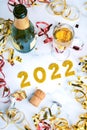 Happy New Year 2022. New Years Eve celebration concept background.Champagne bottle with glass and confetti Royalty Free Stock Photo