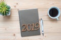 2019 Happy New Year with notebook, black coffee cup, pen and glasses on wooden table, Top view and copy space. New Start, Goals, R Royalty Free Stock Photo