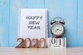 2020 Happy New Year with notebook, retro alarm clock and wooden number. New Start, Resolution, Goals, Plan, Action and Mission