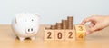 Happy New Year with piggy bank and flipping 2023 change to 2024 block. Resolution, Goals, Plan, Action, Money Saving, Retirement