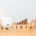 Happy New Year with piggy bank and flipping 2023 change to 2024 block. Resolution, Goals, Plan, Action, Money Saving, Retirement