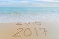 Happy New Year 2017 replace 2016 concept on the summer sea beach. New Year 2017 is coming concept. Royalty Free Stock Photo