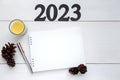 Happy new year 2023. 2023 resolutions list with blank notebook paper, pen and yellow candle on white wooden table. Royalty Free Stock Photo