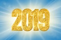 Happy New Year shiny gold number 2019. Golden glitter digits on sun rays bokeh background. Shiny glowing design, light Royalty Free Stock Photo