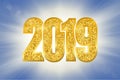 Happy New Year shiny gold number 2019. Golden glitter digits on sun rays bokeh background. Shiny glowing design, light Royalty Free Stock Photo