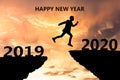 Happy New Year 2020 Silhouette. Young man jumps over a cliff in 2019 to a cliff in 2020