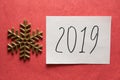 2019 Happy New Year card with text and golden glitter snowflake on pink background