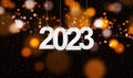Happy New Year 2023 with small glitters sprinkling down. Hanging white paper cut number with festive confetti on an orange golden