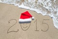 Happy new year 2015 with smiley face in santa hat on sandy beach Royalty Free Stock Photo