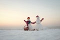 Snowman couple with present box in basket. Royalty Free Stock Photo