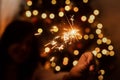 Happy New Year. Stylish girl with burning sparkler celebrating in festive dark room. Happy woman holding firework at christmas Royalty Free Stock Photo