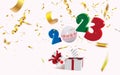 Surprising box with a 2023 numbers and decorations and golden defocused confetti jumping out like a jack in the box Royalty Free Stock Photo