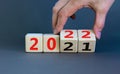 2022 happy new year symbol. Businessman turns a cube, symbolize the change from 2021 to the new year 2022. Beautiful grey Royalty Free Stock Photo