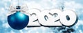 2020 Happy New Year text with blue christmas ball and silver ribbon bow isolated on blurred lights  Background for Flyers and Royalty Free Stock Photo