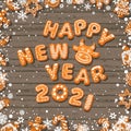 Happy New Year text composed of gingerbread cookies on old wooden table. Cartoon hand drawn letters and numbers 2021. Vector