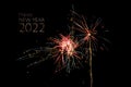 Happy New Year 2022 text and exploding fireworks rockes against a black night sky, copy space Royalty Free Stock Photo