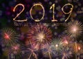 Happy New Year 2019 text hand written sparkles fireworks with Colorful fireworks of various colors at night Royalty Free Stock Photo