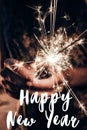 Happy new year text sign, greeting card.hand holding a burning s Royalty Free Stock Photo
