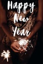 Happy new year text sign, greeting card.hand holding a burning s Royalty Free Stock Photo