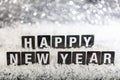 Happy new year text on snow, abstract bokeh lights background Royalty Free Stock Photo