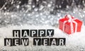 Happy new year text on snow, abstract bokeh lights background Royalty Free Stock Photo