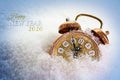 Happy New Year 2020 text and a vintage alarm clock in the snow shows five minutes before twelve, concept greeting card with copy Royalty Free Stock Photo