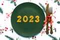 Happy new year 2023. Top view of golden Numbers 2023 on plate with cutlery for Christmas dinner. New Years Eve celebration concept