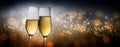 Happy New Year 2020, two champagne glass flutes toasting against a dark background with blurry bokeh lights, party concept in Royalty Free Stock Photo