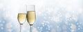 Happy New Year 2020, two champagne glass flutes toasting against a light blue bubble bokeh background, party concept in panoramic Royalty Free Stock Photo