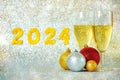 Happy new year 2024. Two glasses of champagne with christmas balls and golden numbers with the number 2024. New Years Eve