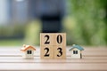 Happy new year 2023. Two house model with 2023 wooden blocks number. Royalty Free Stock Photo