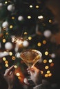 Happy New Year! Woman celebrating with fireworks and champagne glass against christmas tree lights Royalty Free Stock Photo