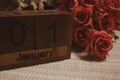 Happy New year with Wooden cube calendar with date January 01 and bouquet of roses. New year Date Special Royalty Free Stock Photo