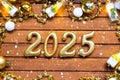 Happy New Year wooden numbers 2025 on cozy festive brown wooden background with sequins, snow, lights of garlands. Greetings,